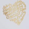 A heart shaped gold foil sticker with words written in it.