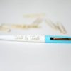 A blue pen with writing on it next to some matches.