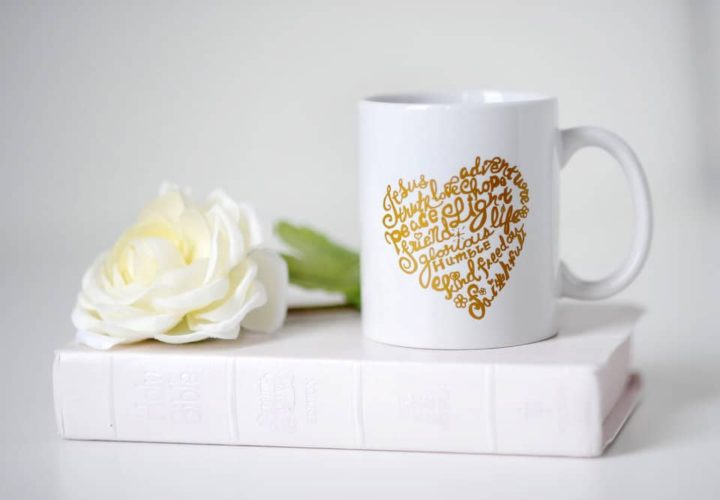 A white coffee mug with gold heart on it.