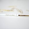 A white pen with gold writing on it.