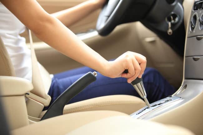 A person is holding the steering wheel of their car.