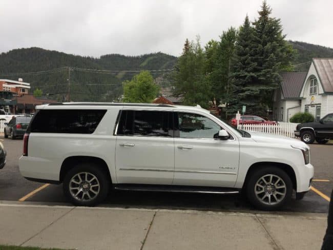 A white suv parked on the side of a road.