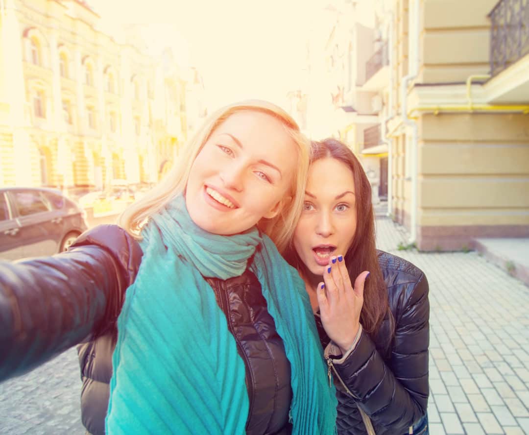 Two women taking a selfie on the street.