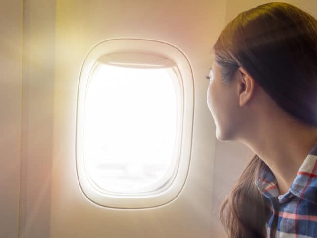 A woman looking out of an airplane window.